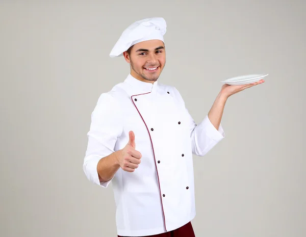 Επαγγελματίας σεφ στο λευκή στολή και καπέλο, σε γκρι φόντο — Φωτογραφία Αρχείου