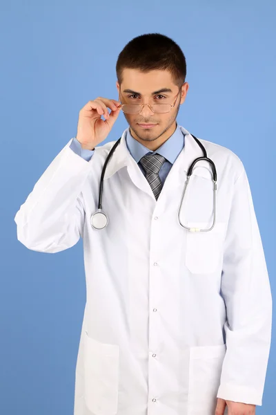 Dottore maschio in piedi su sfondo blu — Foto Stock