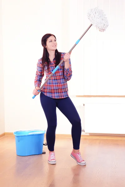 Ung hemmafru med mopp i rum — Stockfoto