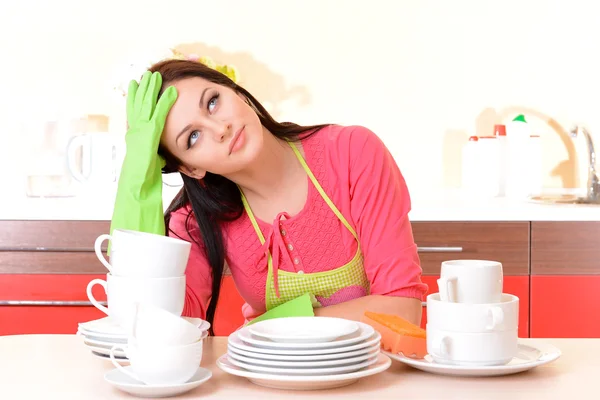 Mooie jonge vrouw veegt schoon gebruiksvoorwerpen in keuken — Stockfoto