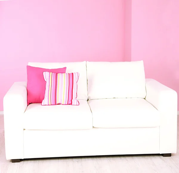 Sofá blanco en la habitación sobre fondo rosa — Foto de Stock