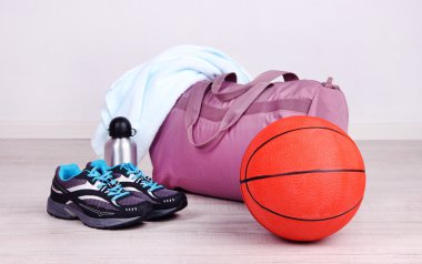 Sports bag with sports equipment in gymnasium clipart