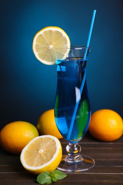 koyu mavi zemin üzerine masada kokteyl bardak