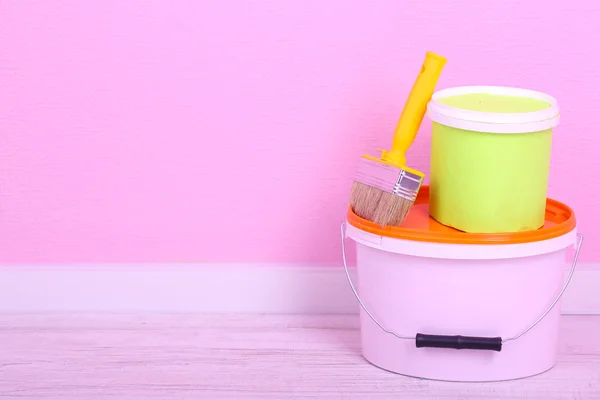 Verf en penseel op verdieping in de kamer op de muur achtergrond — Stockfoto