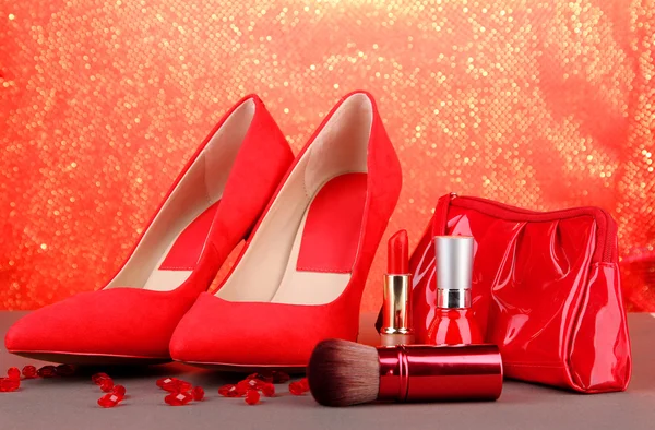 Beautiful red female shoes and cosmetics, on bright background — Stock Photo, Image