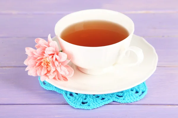 Růžové chryzantéma a šálek čaje na dřevěný stůl — Stock fotografie