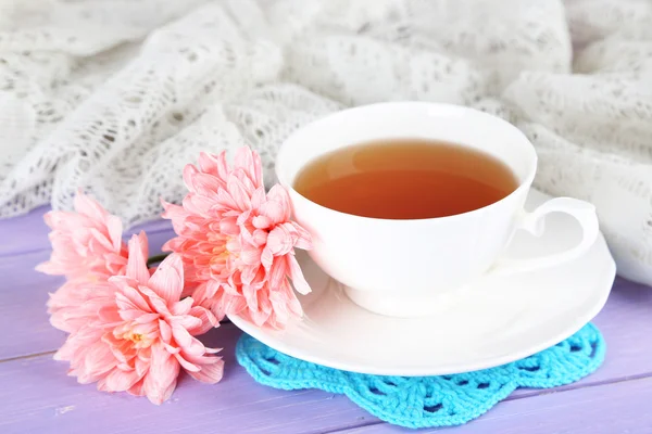 Crisantemos rosados y taza de té sobre mesa de madera —  Fotos de Stock