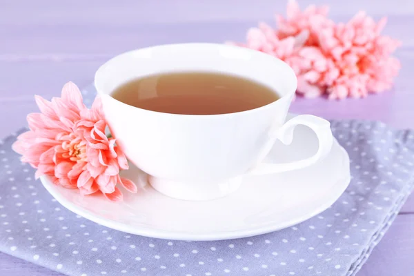Różowy chryzantemy i filiżankę herbaty na drewnianym stole — Zdjęcie stockowe