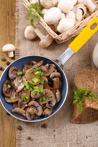 Heerlijke gebakken champignons in pan op tafel close-up — Stockfoto