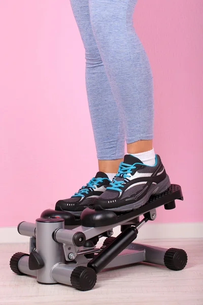 Woman doing exercise on stepper. Close-up on legs. — Stock Photo, Image