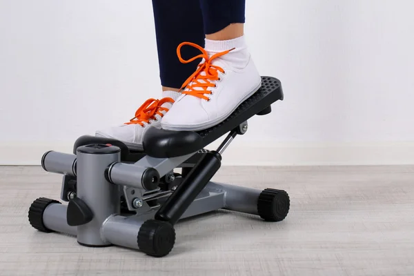 stock image Woman doing exercise on stepper. Close-up on legs.