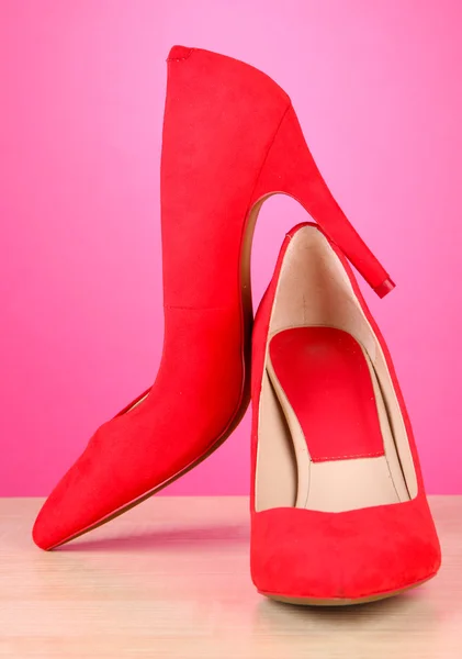 Piękne czerwone buty kobiece, na tle różowy — Zdjęcie stockowe