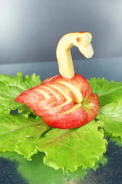 Carving fruit pattern of swan on grey wet background — Stock Photo, Image