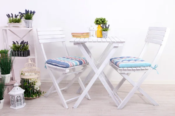 Garden chairs and table with flowers on wooden stand on white background — Stock Photo, Image