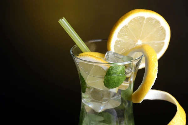 Склянка коктейлю з лимоном і м'ятою на темно-жовтому фоні — стокове фото