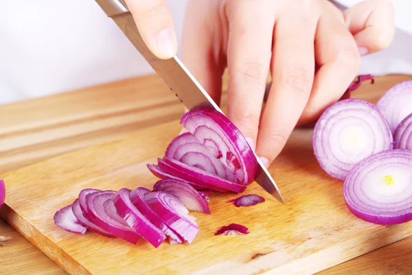 Ręce kobiet cięcia cebuli, na tle kuchni — Zdjęcie stockowe