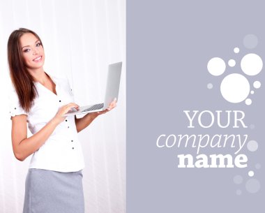 Genç güzel iş kadını ofiste dizüstü bilgisayar ile