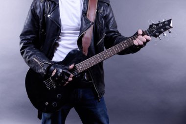 genç müzisyen gitar çalıyor ve şarkı söyleme, koyu renk arka plan üzerinde