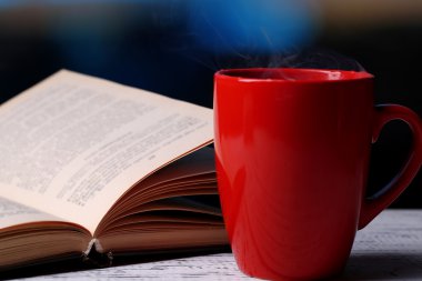 sıcak çay ile parlak arka masada kitap