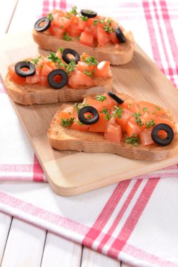 Kesme tahtasında domatesli lezzetli bruschetta.