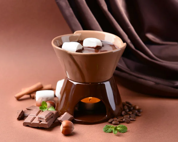 Fondue de chocolate con caramelos de malvavisco, sobre fondo marrón — Foto de Stock