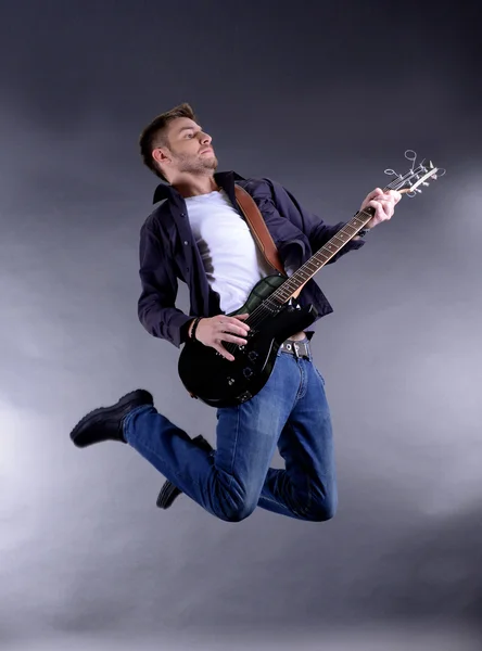 Jovem músico tocando guitarra, isolado em branco — Fotografia de Stock