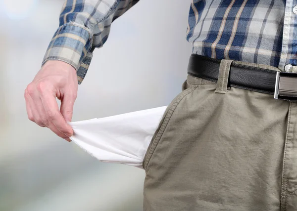 Man showing his empty pocket on bright background — Stock Photo, Image