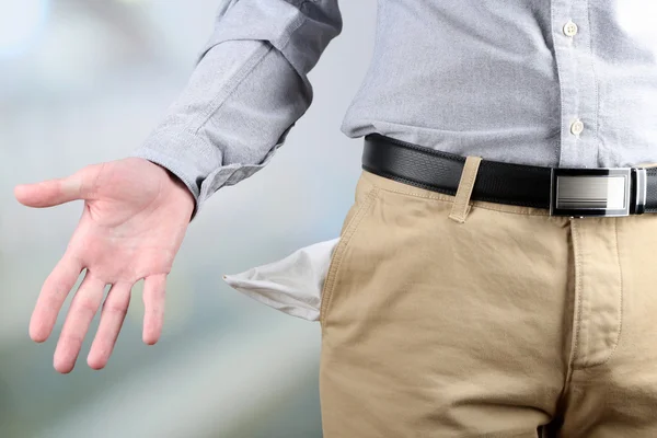 Man showing his empty pocket on bright background — Stock Photo, Image