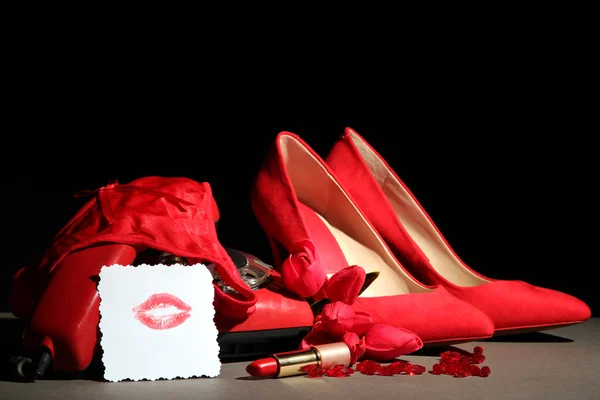 Hermosos zapatos femeninos rojos y teléfono retro, sobre fondo negro —  Fotos de Stock