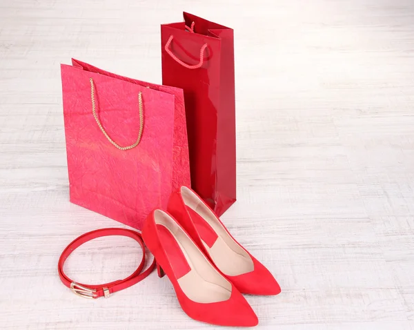 Belles chaussures féminines rouges, ceinture et sacs de magasin — Photo