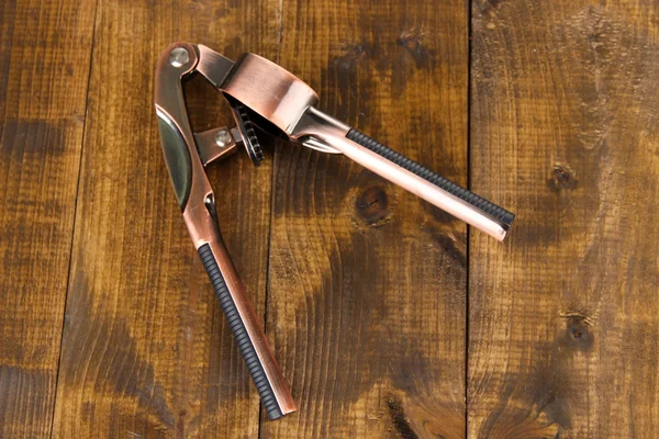 Garlic press on wooden background — Stock Photo, Image