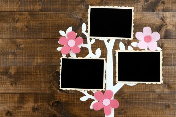 Holder in form of tree with instant photo cards on wooden background — Stock Photo, Image