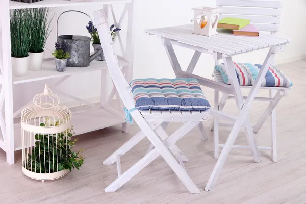 Ogrodowe krzesła i stół z kwiatami na półkach na białym tle — Zdjęcie stockowe