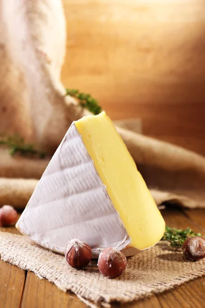 Sabroso queso Camembert con tomillo y nueces, sobre mesa de madera —  Fotos de Stock