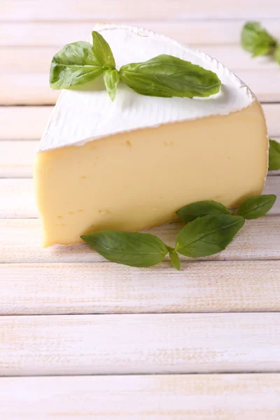 Queijo saboroso Camembert com manjericão, sobre mesa de madeira — Fotografia de Stock