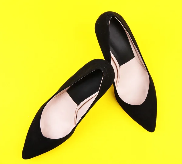 Vackra svarta kvinnliga skor, på gul bakgrund — Stockfoto