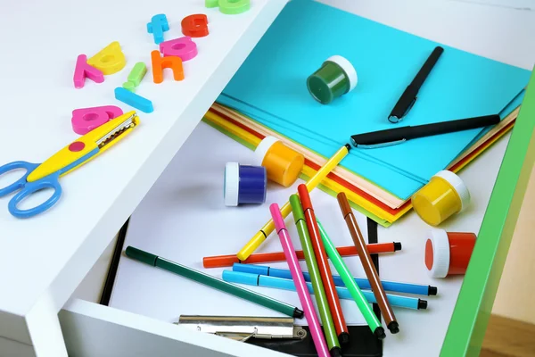 School supplies in open desk drawer close up — Stock Photo, Image