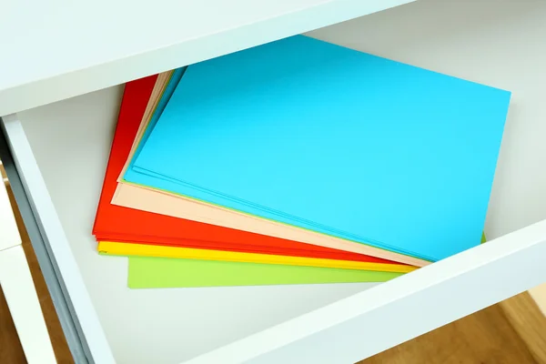 Colorful paper in open desk drawer close up — Stock Photo, Image