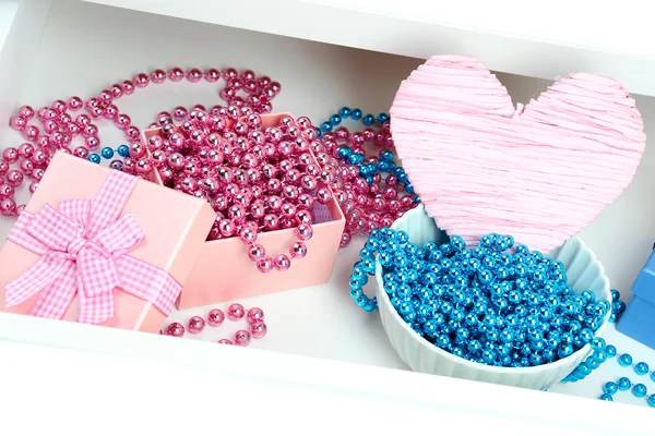 Gift boxes and beads in open desk drawer close up — Stock Photo, Image