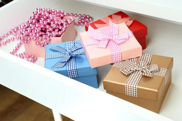 Coffrets cadeaux et perles dans le tiroir de bureau ouvert fermer — Photo