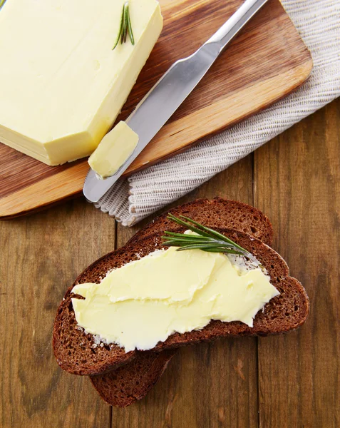 Segment van roggebrood met boter op houten tafel — Stockfoto