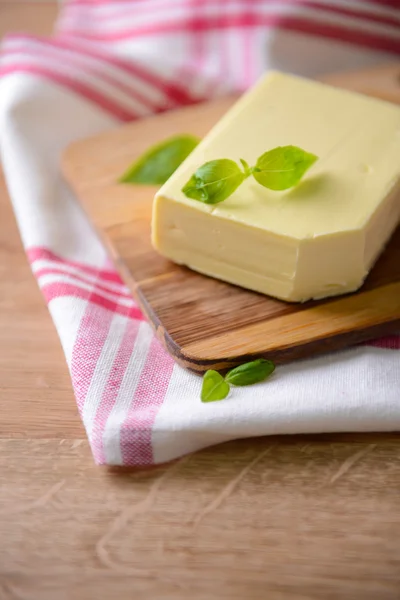 Beurre savoureux sur planche à découper en bois — Photo