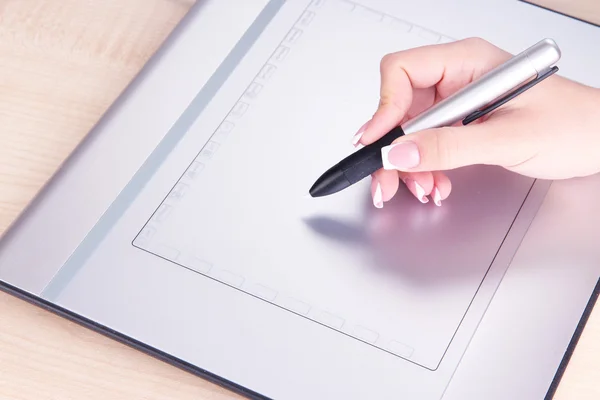 Vrouwelijke hand met grafisch tablet op tafel close-up — Stockfoto