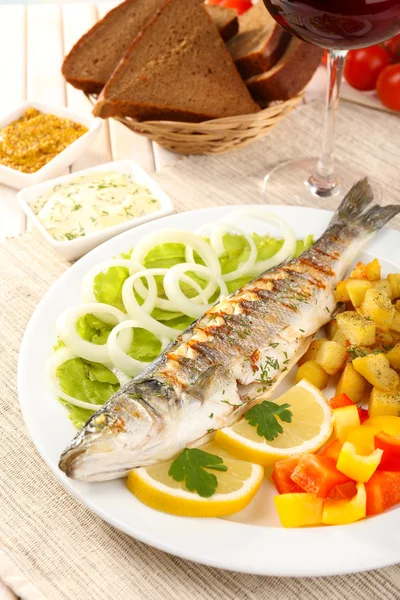 Delicioso pescado a la parrilla en el plato en primer plano de la mesa —  Fotos de Stock