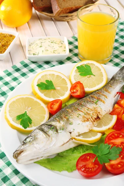 Delicious grilled fish on plate on table close-up — Stock Photo, Image