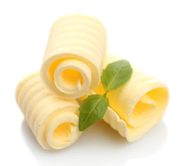 Krullen van verse boter met basilicum, geïsoleerd op wit — Stockfoto