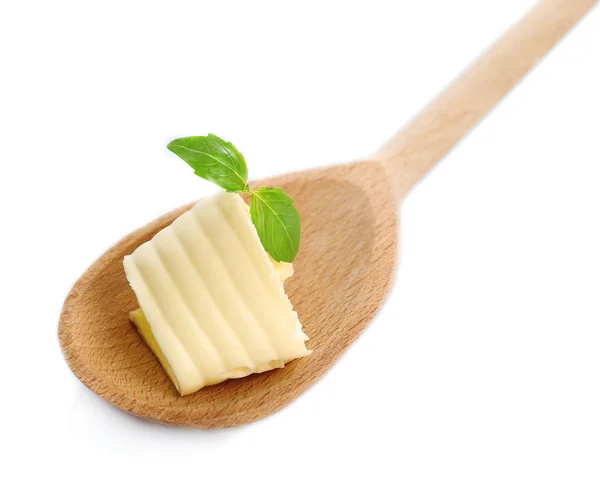 Curl of fresh butter with basil on wooden spoon, isolated on white — Stock Photo, Image