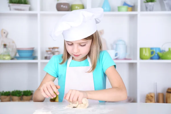 Liten flicka förbereda kakan degen i köket hemma — Stockfoto