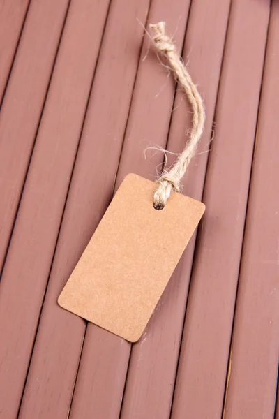 Etiqueta marrón sobre fondo de madera de color —  Fotos de Stock