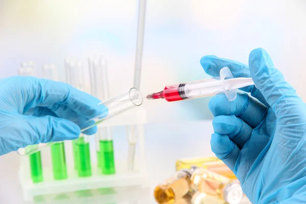 Technician injecting blood sample in test tube analysis, on light background — Stock Photo, Image